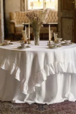 Round linen wedding tablecloth draped on a round table in an elegant rustic wedding setting