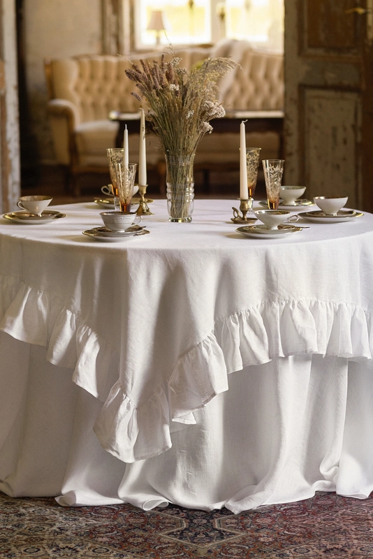 Round linen wedding tablecloth draped on a round table in an elegant rustic wedding setting