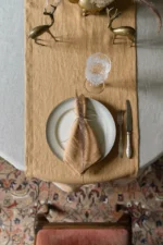 Camel brown linen table runner styled on a table in a neutral setting