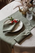 Sage green linen table runner styled on a table for wedding or event decor