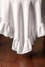White linen ruffled tablecloth styled for a wedding reception table